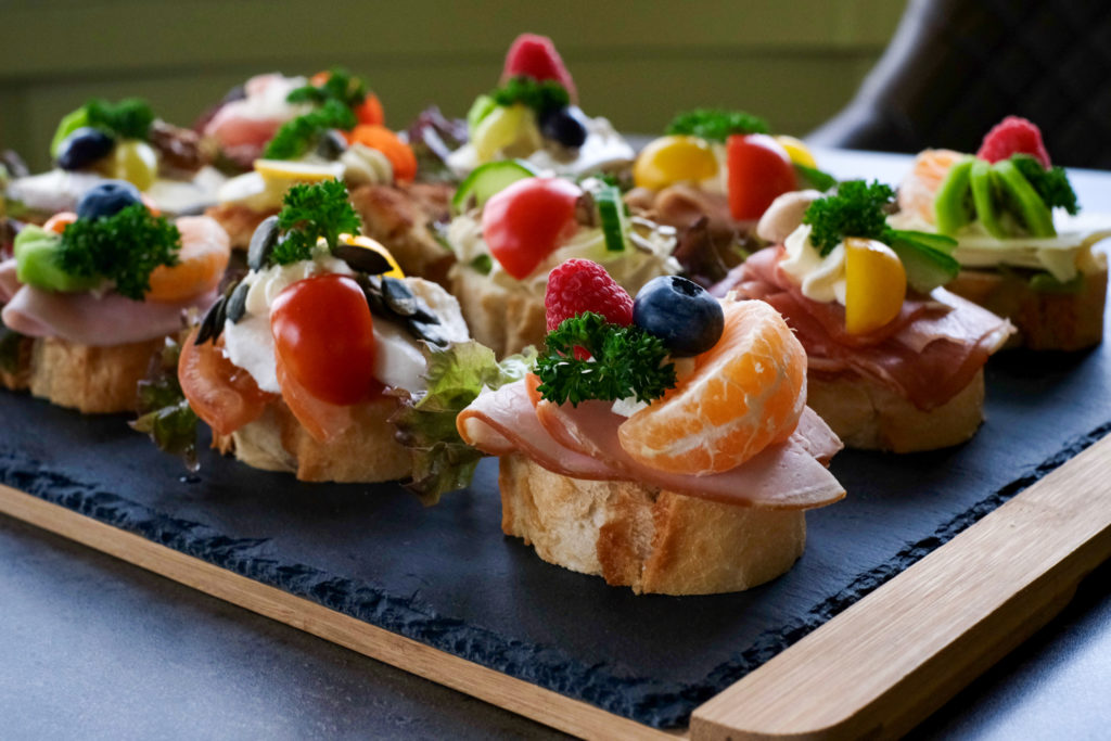 Bunte Canapés auf Schieferplatte serviert.