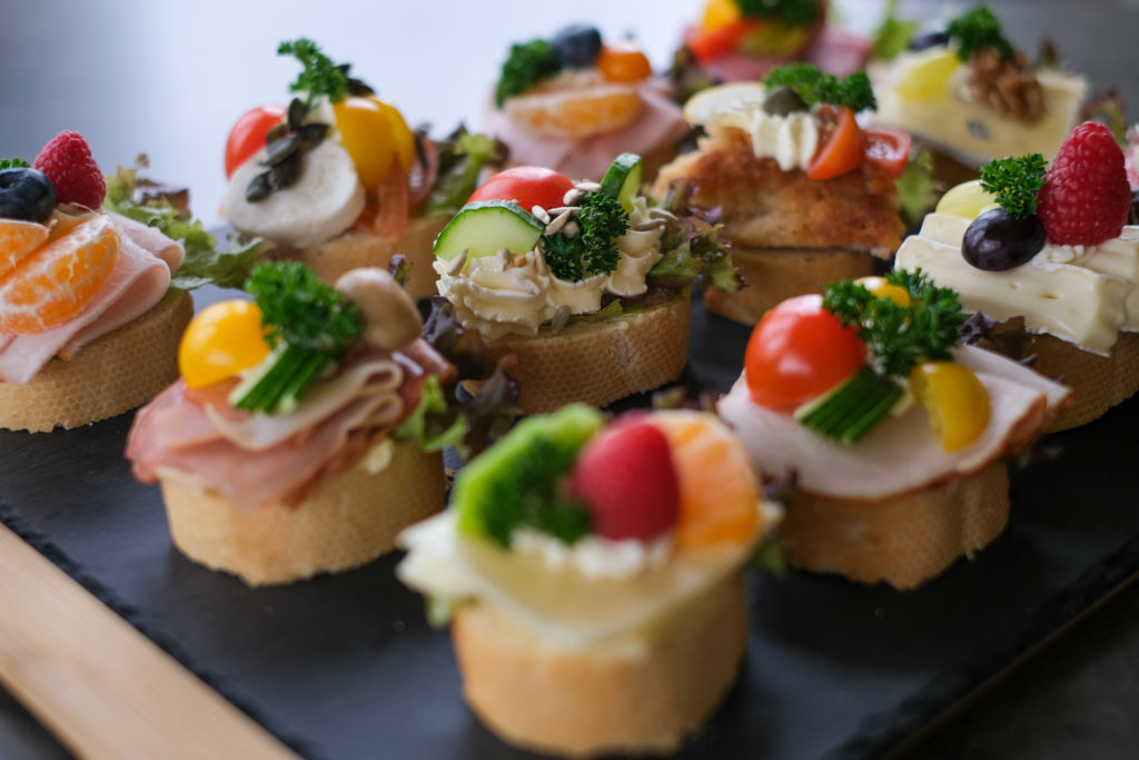 Bunte Canapés mit Obst und Gemüse auf Baguette