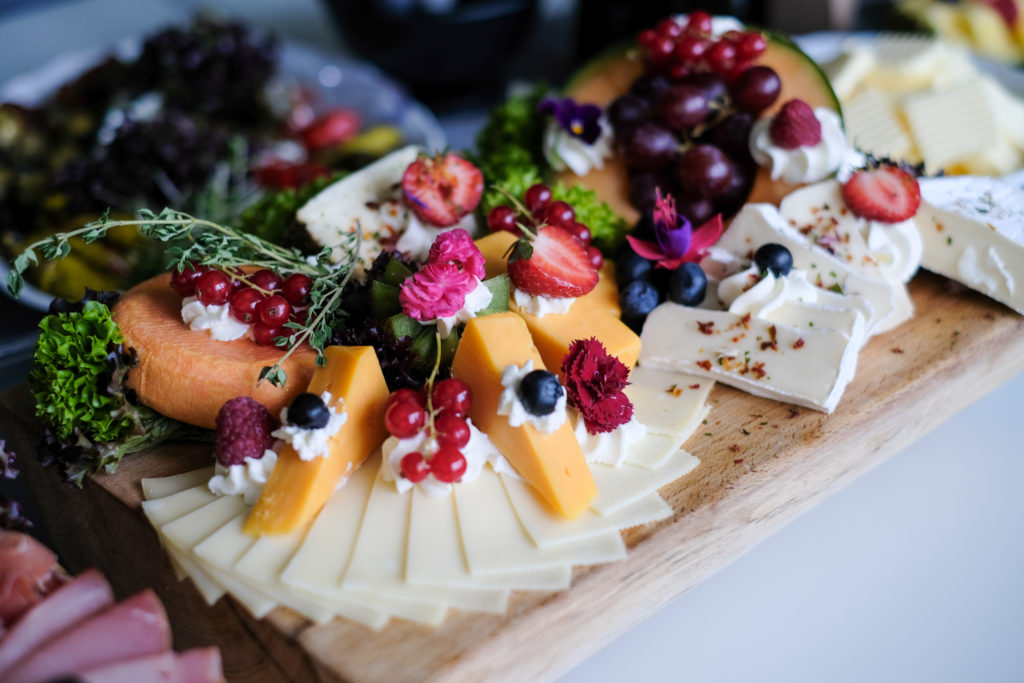 Catering und Buffet: Käseplatte mit Obst und Kräutern, dekoriert.