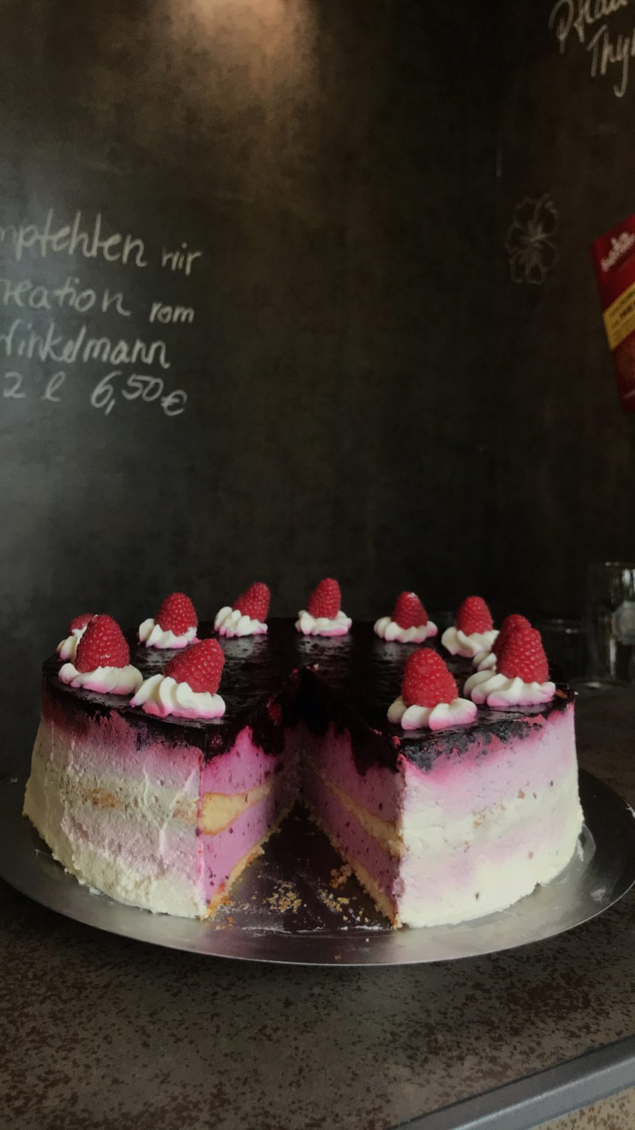 hausgemachte, zweistöckige Waldbeerentorte dekoriert mit Himbeeren